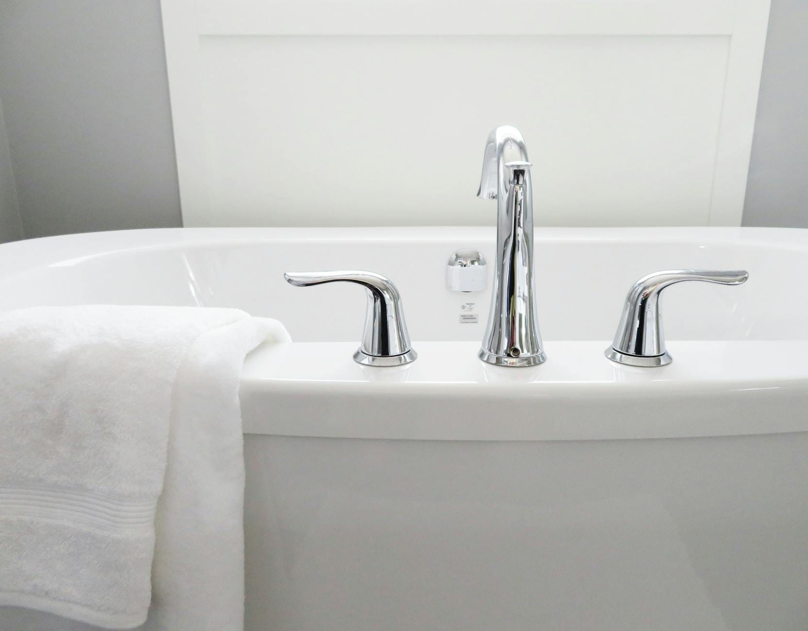 Biała, nowoczesna wanna z chromowaną baterią w domowym SPA Biała, nowoczesna wanna z chromowaną baterią w domowym SPA