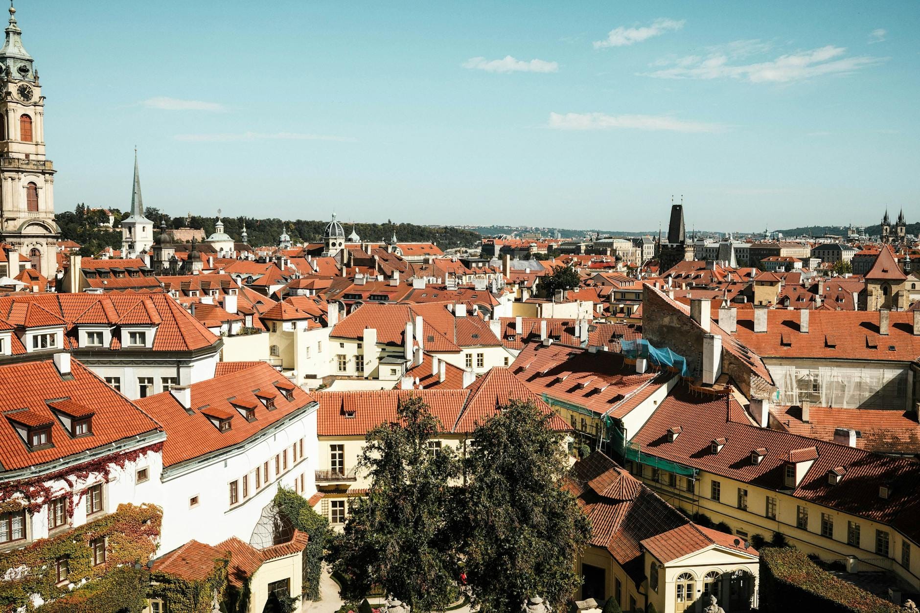 Jak tanio zaplanować city break w Europie – praktyczny przewodnik po najtańszych kierunkach Czerwone dachy i wieże zabytkowego centrum Pragi w słoneczny dzień