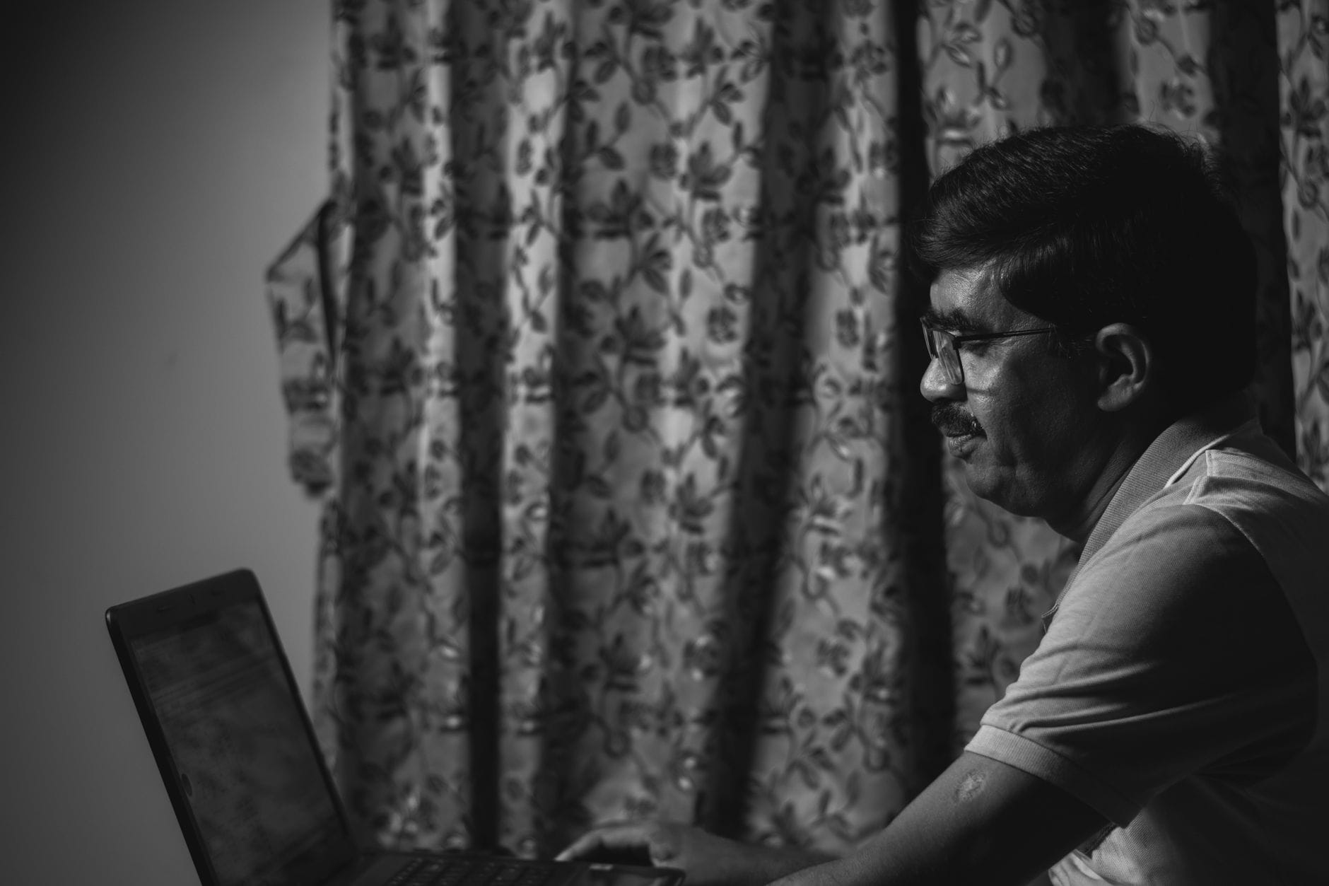 Mężczyzna przy laptopie w skupieniu pracuje nad lokalną sztuczną inteligencją